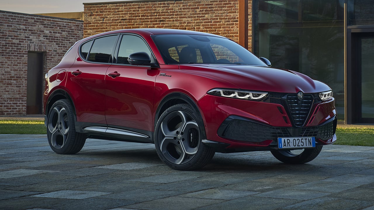 Vue 3/4 avant et latérale du Alfa Romeo Tonale 2026, stationné devant un batîment publique