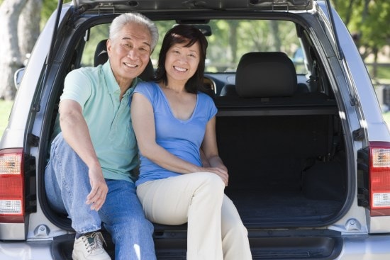 Couple sitting in back of van smiling