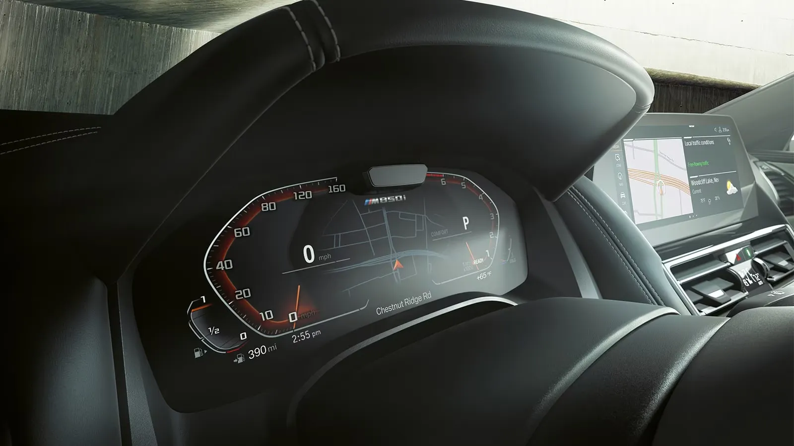 Close-up of the 2025 BMW M850i digital instrument cluster displaying integrated navigation with the central multimedia screen in the background.