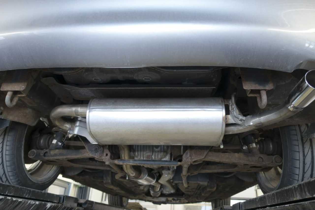 The catalytic converter underneath a silver Toyota vehicle.