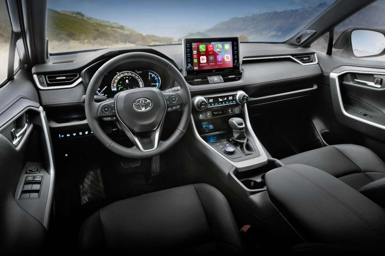 An interior view of the 2024 Toyota RAV4 cockpit, showcasing the drivers seat and steering wheel.