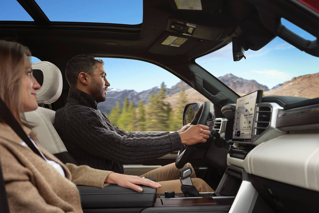 A male driver and female passenger sit in the front row of the 2025 Toyota Sequoia.