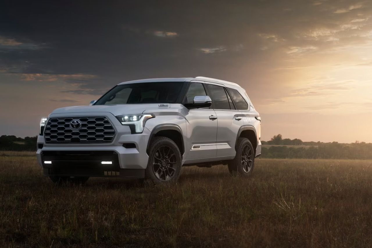 The all-new Toyota Sequoia model for 2025, in white, posed on a grass field on a moody afternoon.