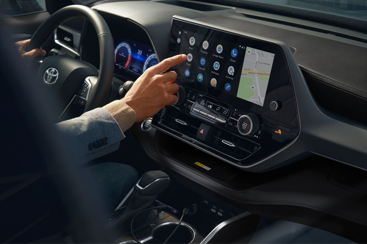 A man sits in the drivers seat of a 2025 Toyota Pathfinder and clicks on the touchscreen display to connect his phone.