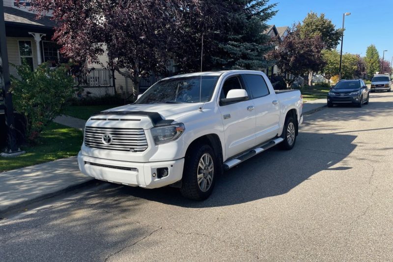 Jason's 1 million km Toyota Tundra is parked on a residential road with homes in the background.