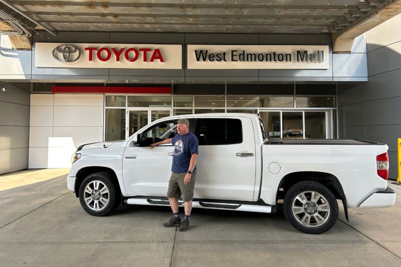 Jason stands in front of his white 1 million km Toyota Tundra at the West Edmonton Mall Toyota dealership.